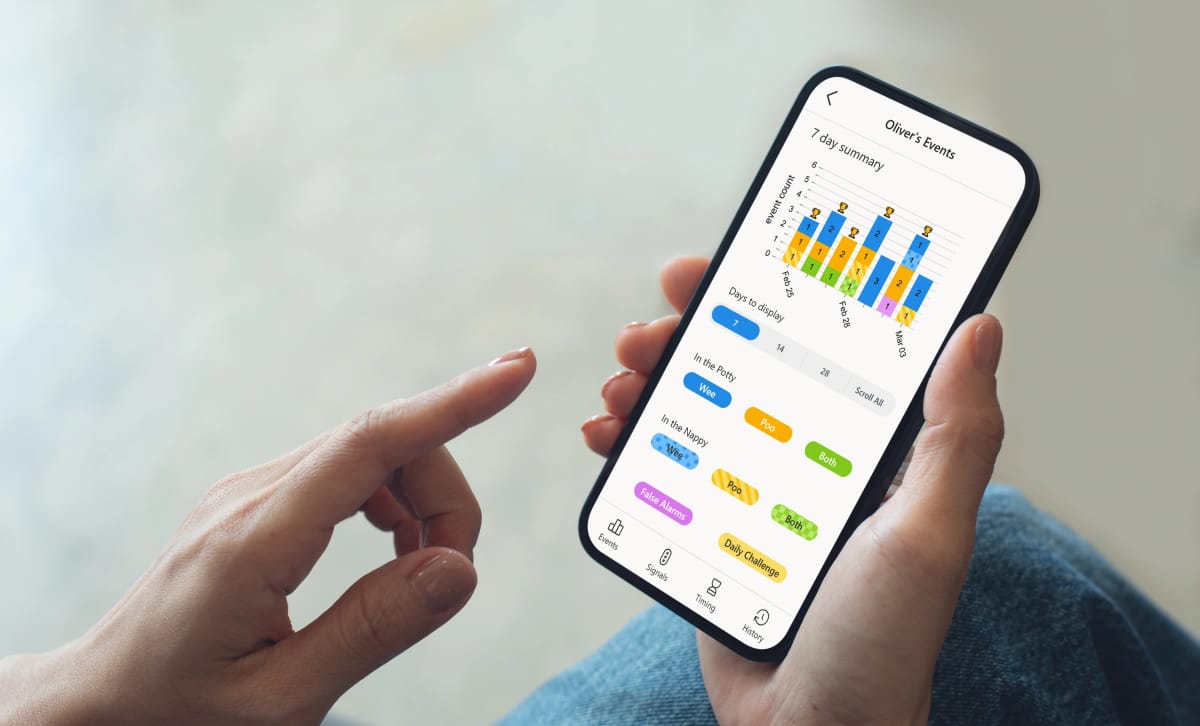 A mothers hands holding a phone and using the ec babies app