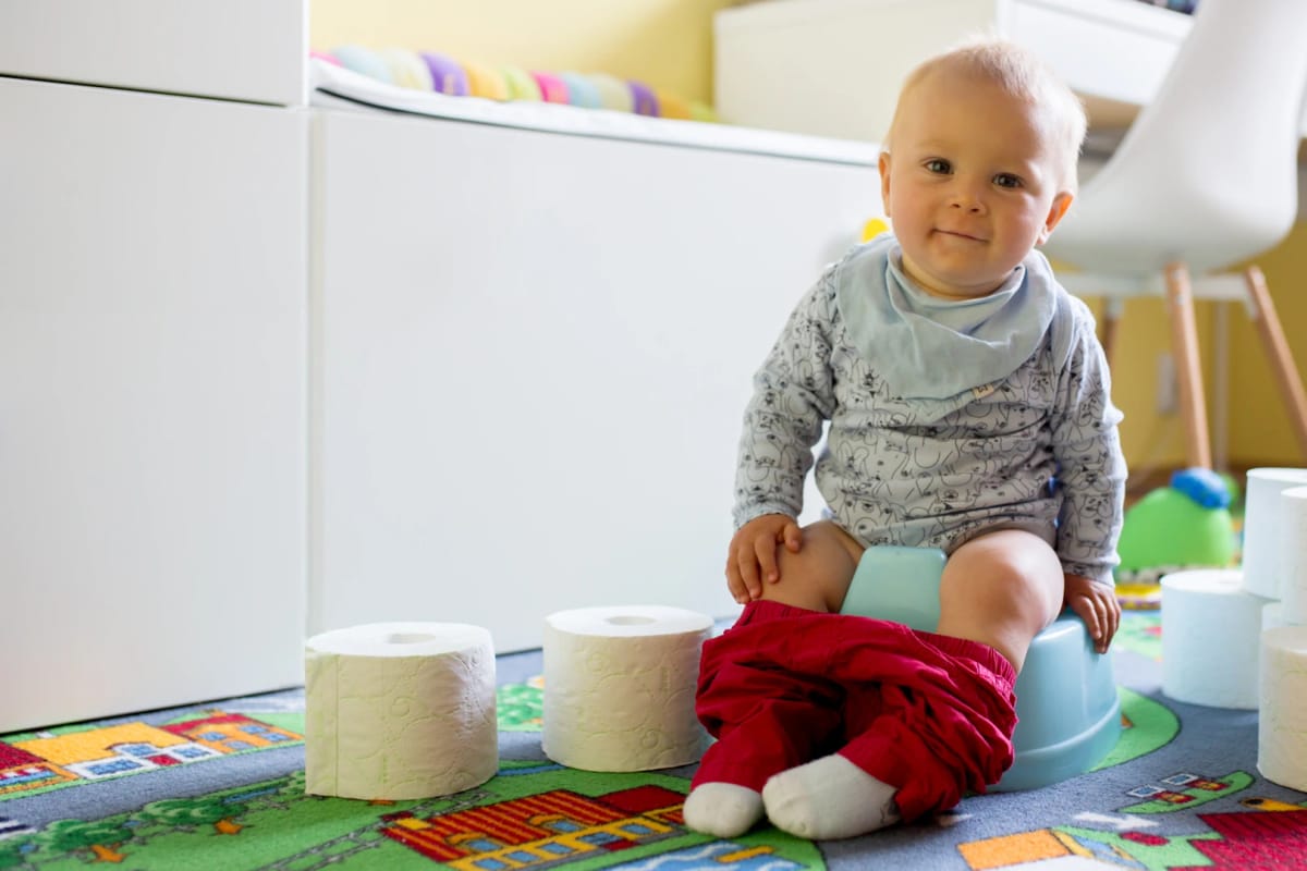 A baby sitting comfortably on a potty