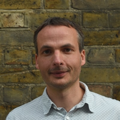 Elimination Communication with a newborn, mother holding a newborn over a sink to pee