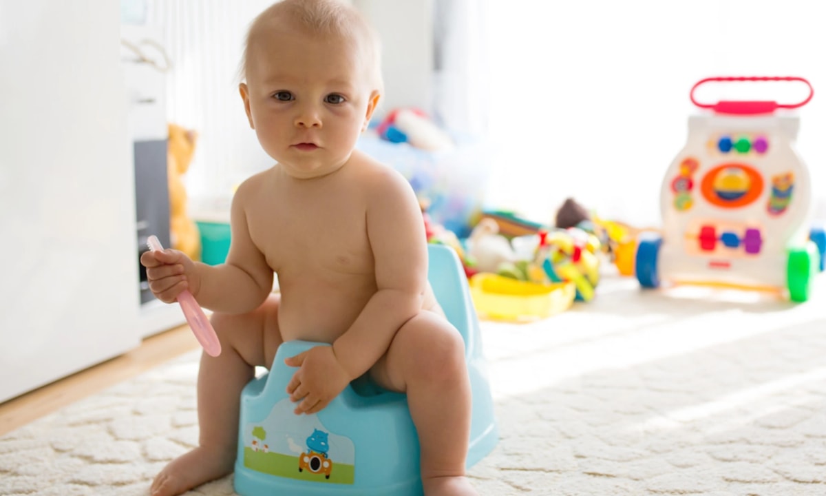 Young baby sitting on a potty doing elimination communication