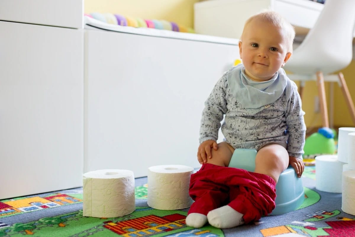 A baby sitting comfortably on a potty