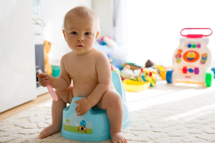 Young baby sitting on a potty doing elimination communication